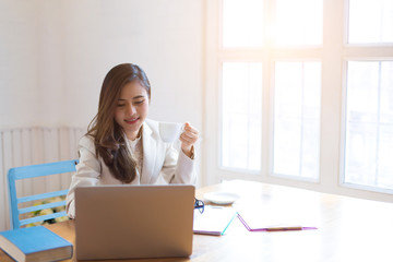 Protrait of Beautiful businesswoman sitting at desk and working with laptop computer.