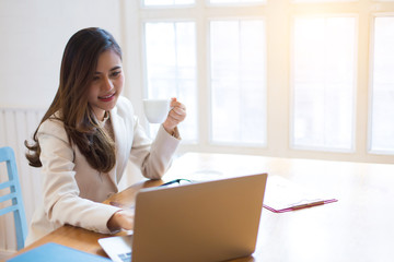 Protrait of Beautiful businesswoman sitting at desk and working with laptop computer.