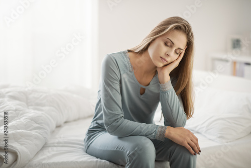 Fotomural Exhausted woman sitting on bed