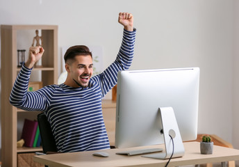 Wall Mural - Happy young man after winning computer game at home