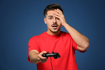 Wall Mural - Young man after losing video game on color background