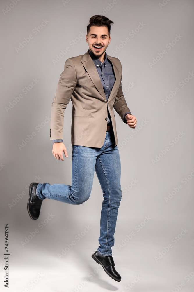 Jumping handsome man on grey background