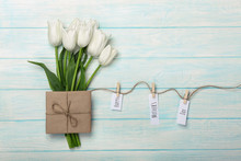 A Bouquet Of White Tulips And Envelope With A Stickers With Clothespins On A Rope And Blue Wooden Boards . Mother's Day