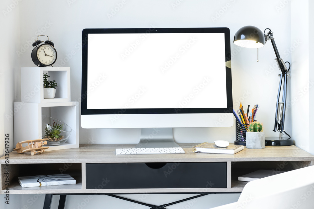 Stylish workplace with modern computer near white wall
