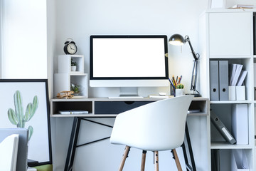 Stylish workplace with modern computer near white wall