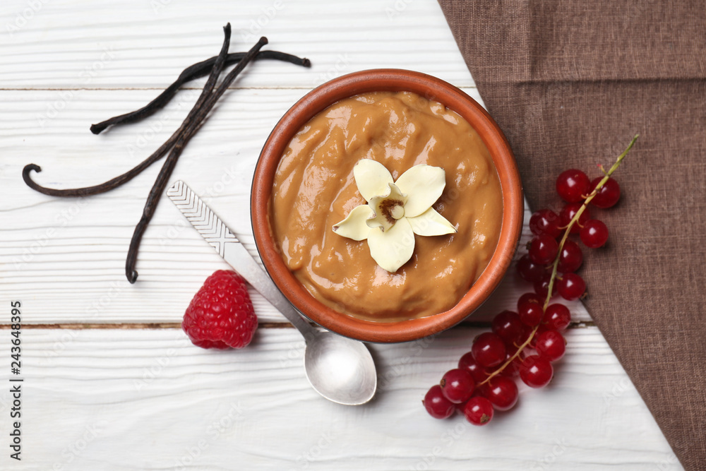 Tasty vanilla dessert on white wooden table