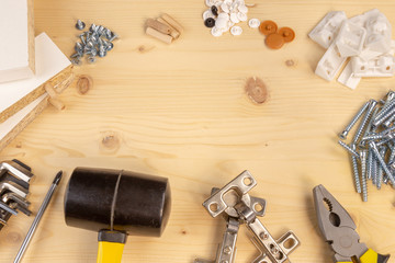 Furniture assembly components and tools arranged in a still life on a table. Background with copy space.