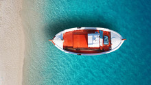 Aerial Drone Bird's Eye Top View Of Colourful Traditional Fishing Boat In Turquoise Clear Waters, Aegean Sea, Greece