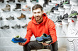 © rh2010 - Portrait of a man in the fitting room of the modern sports shop choosing trail shoes for hiking