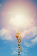 Wall Mural - Telecom worker repairing antenna tower on blue sky background, cellular tower system.