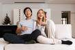 © Drobot Dean - Cheerful young couple sitting together on a couch