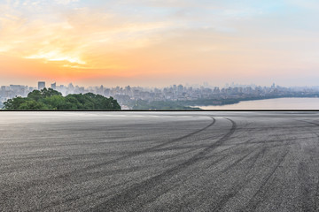 Panoramic city skyline and buildings with empty asphalt road at sunrise