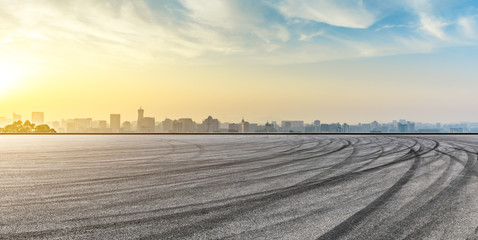 Panoramic city skyline and buildings with empty asphalt road at sunrise