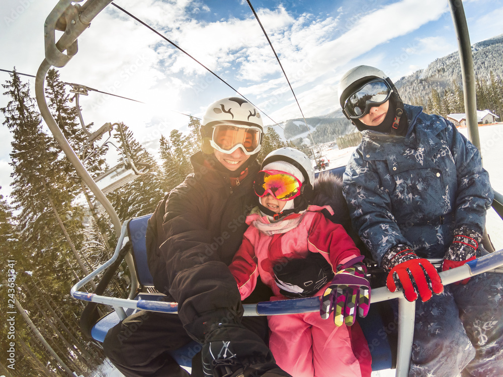 happy smiling family skiers on ski lift making selfie - obrazy, fototapety, plakaty 