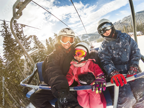 Fotografía happy smiling family skiers on ski lift making selfie