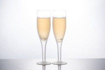 Glasses with champagne empty and filled on a white background.