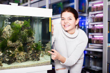 Wall Mural - Teenager shows an aquarium with barbus fishes