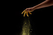 cropped view of woman sprinkling yellow holi powder on black background