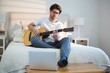 © WavebreakMediaMicro - Man playing guitar in bedroom