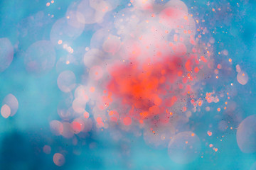 Wall Mural - blurred glowing red glitter on blue background