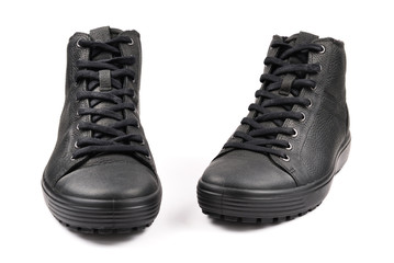 Men's black leather shoes and a black camera on a black background. Copy space.