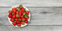 Tabletop View - Plate With Strawberries On Gray Wooden Desk, Place For Text On Right.