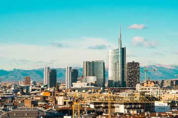 Canvas Print - Milan skyline with modern skyscrapers in Porta Nuova business district in Italy. Panoramic view of Milano city. The mountain range of the Lombardy Alps in the background.