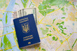 © Nataliya Pokrovska - New Ukrainian international passport with dollars cash inside on map background. Travel and free visa law concept. Innovations in Ukraine.
