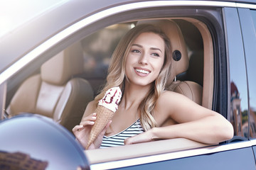 Wall Mural - woman sitting in the car and holding ice cream