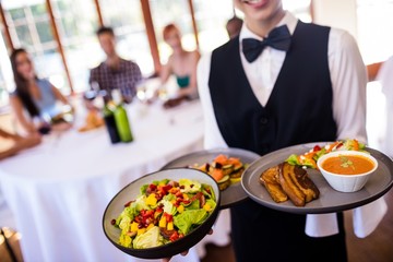 Wall Mural - Waitress holding food on plate in restaurant