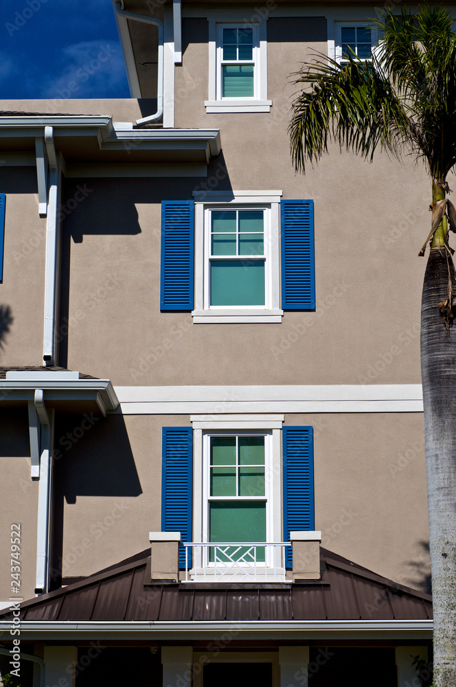 Generic House Outside Sunlit exterior wall of generic florida home showing shutters on ...
