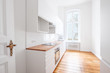 new built-in kitchen with white furniture and wooden floor