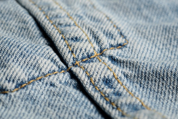 Blue jeans fabric macro seam pattern blurred background. Denim background texture for design.  