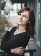 © Matt Benzero - Casual portrait of cute and positive girl on the balcony with park on background. Pretty brown haired woman posing to camera. Charming model in black shirt. photo of fashionable girl with style.