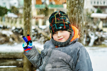 Portrait of a boy on a winter walk . Cheerful child on the street