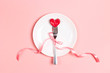 Fork with a heart on a plate on a pink table. Festive menu for Valentine's Day. T
