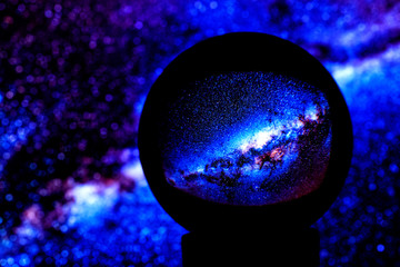 stars of the milky way galaxy are reflected in a crystal ball