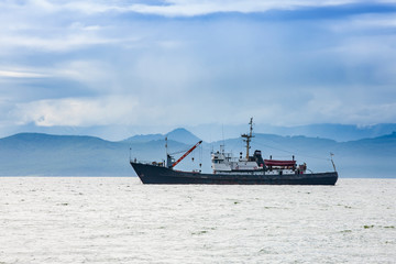 Wall Mural - large fishing vessel on the background of hills