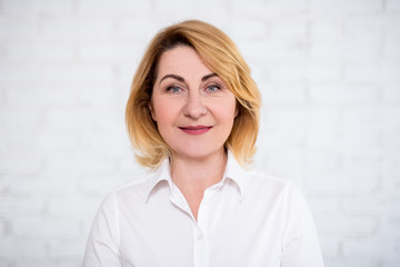 Wall Mural - close up portrait of mature woman over white wall