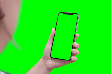 Modern smart phone with round edges in hand. Close-up. Isoalted screen and background in green, chroma key.