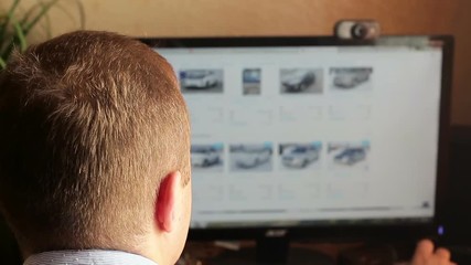 A man chooses a car in the online store. Online shopping