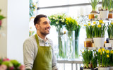 Fototapeta  - sale, small business and floristry concept - happy smiling florist man or seller at flower shop