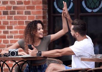 Poster - Portrait of a young  couple sitting down at a cafe outside