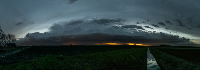 Wall Mural - panorama of a thunderstorm over the dutch landscape after sunset. beautiful storm structures after s
