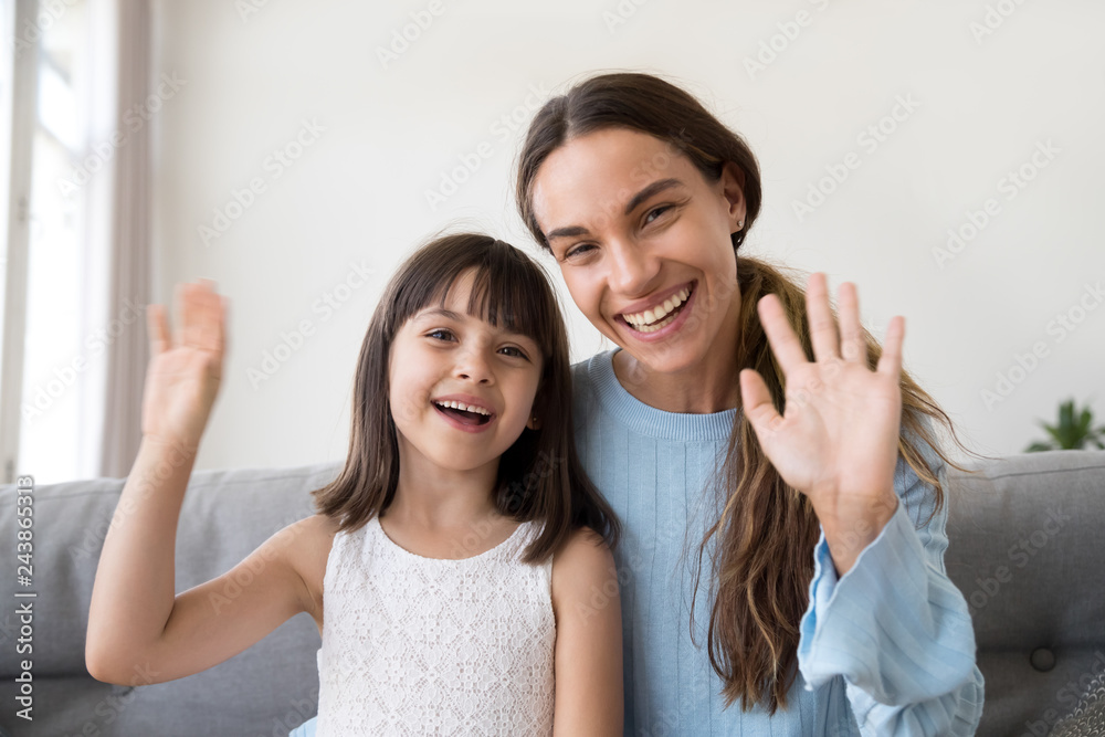 Photo Stock Happy mom and cute kid daughter waving hands looking at ...