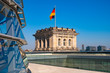 Berlin, Germany - Rooftop of the Reichstag building with the glass panoramic Bundestag dome and historic corner tower with Germany flag