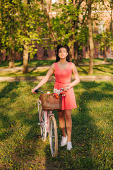 Wall Mural - Latin woman in pink dress with flowers and pink bicycle.