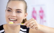 © lenetsnikolai - Smiling young woman with healthy teeth brushing her teeth