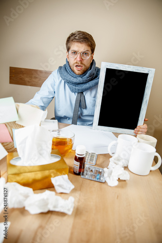 Sick Man With Empty Poster For Copyspace While Working In Office Businessman Caught Cold Seasonal Flu Pandemic Influenza Disease Prevention Illness Virus Infection Temperature Fever And Flu Buy This Stock Photo