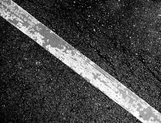 crack and texture of asphalt road with white dashed line top view background.